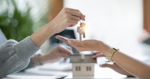 Female realestate agent giving house key to her customer, property, realestate concept.