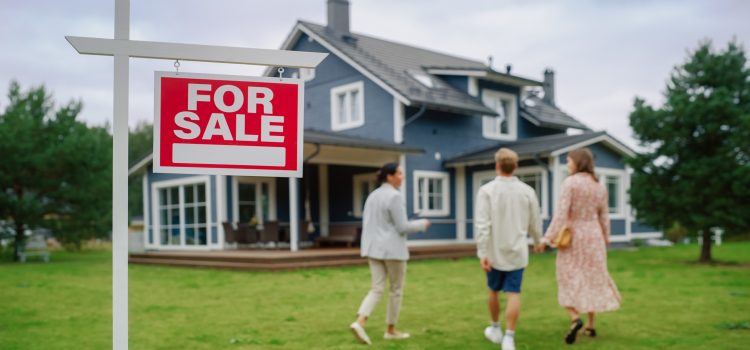 real estate agent Meeting a Beautiful Successful Couple in Front of a Modern Big House That is For Sale. Real Estate Agent Selling or Renting Out a New Home to a Young Family. For Sale Sign on Front Lawn.